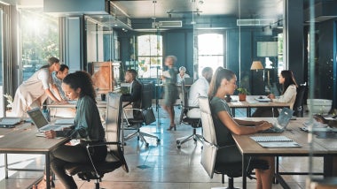 Corporate business people working in busy marketing office space, planning strategy in books and reading email on laptop at work. Businessman, businesswoman and workers at startup advertising company.